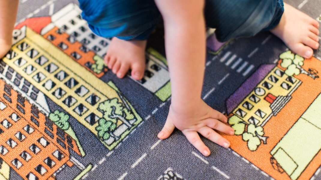 Barnhänder och -fötter på matta