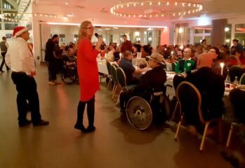 En person håller i en mikrofon på en stor julfest