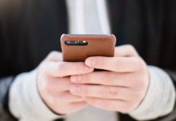 Två händer håller i en mobiltelefon