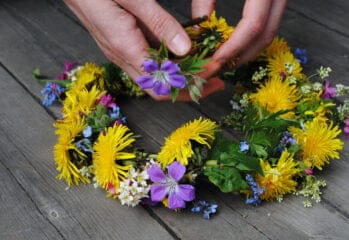 Ett par händer sätter ihop en blomsterkrans
