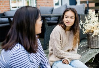 Två personer sitter utomhus