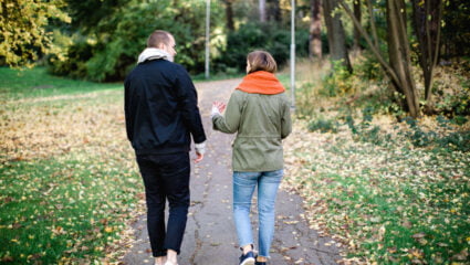 man och kvinna på promenad rygg mot kamera