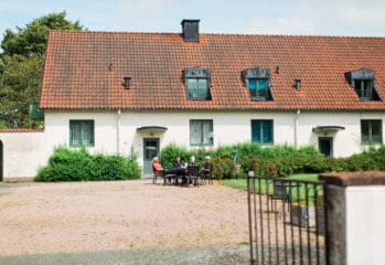 Personer vid ett bord utanför en vit byggnad