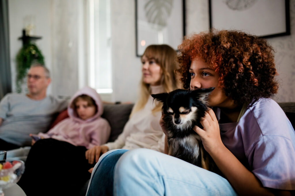 familj med hund tittar på tv