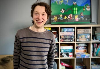 Hampus framför hylla med spel och tavla med Mario-figurer