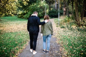 Två personer promenerar med ryggen mot kameran