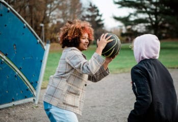 Två barn leker med en basketboll