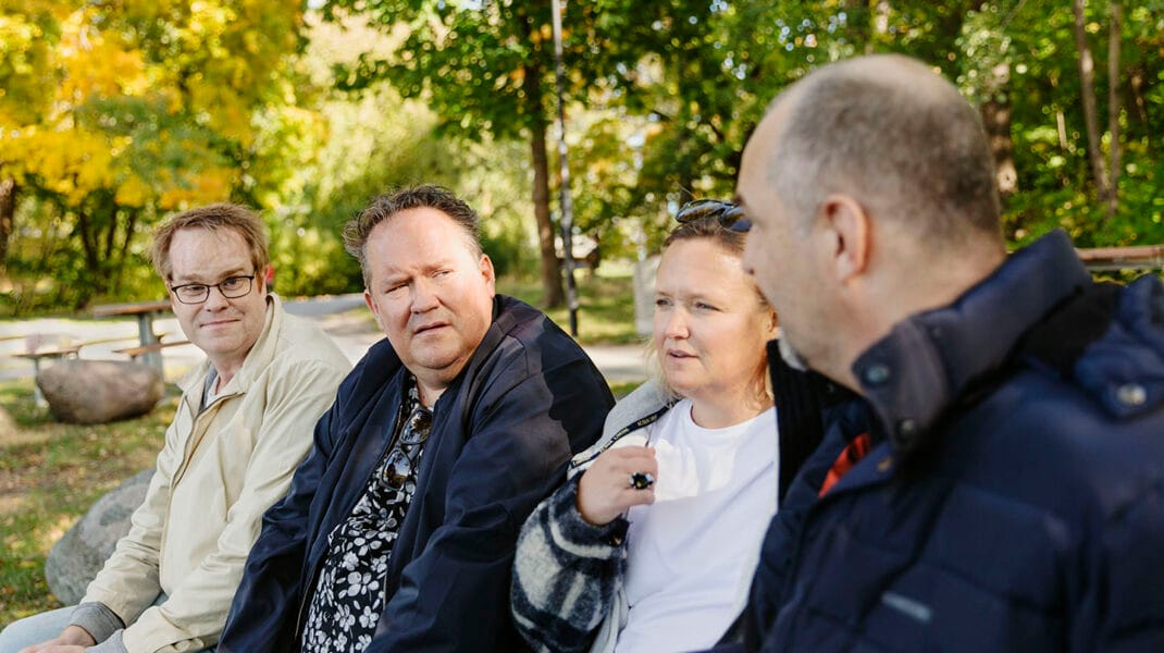 fyra personer sitter i en park