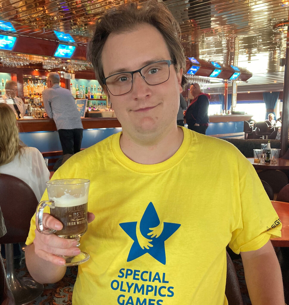 Nils i gul t-tröja, med drinkglas i handen