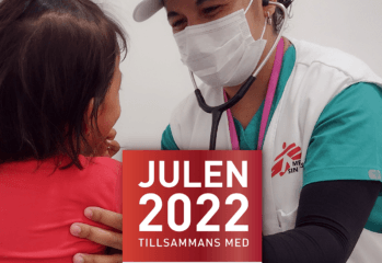 En läkare från Läkare utan gränser undersöker en person med ryggen från kameran
