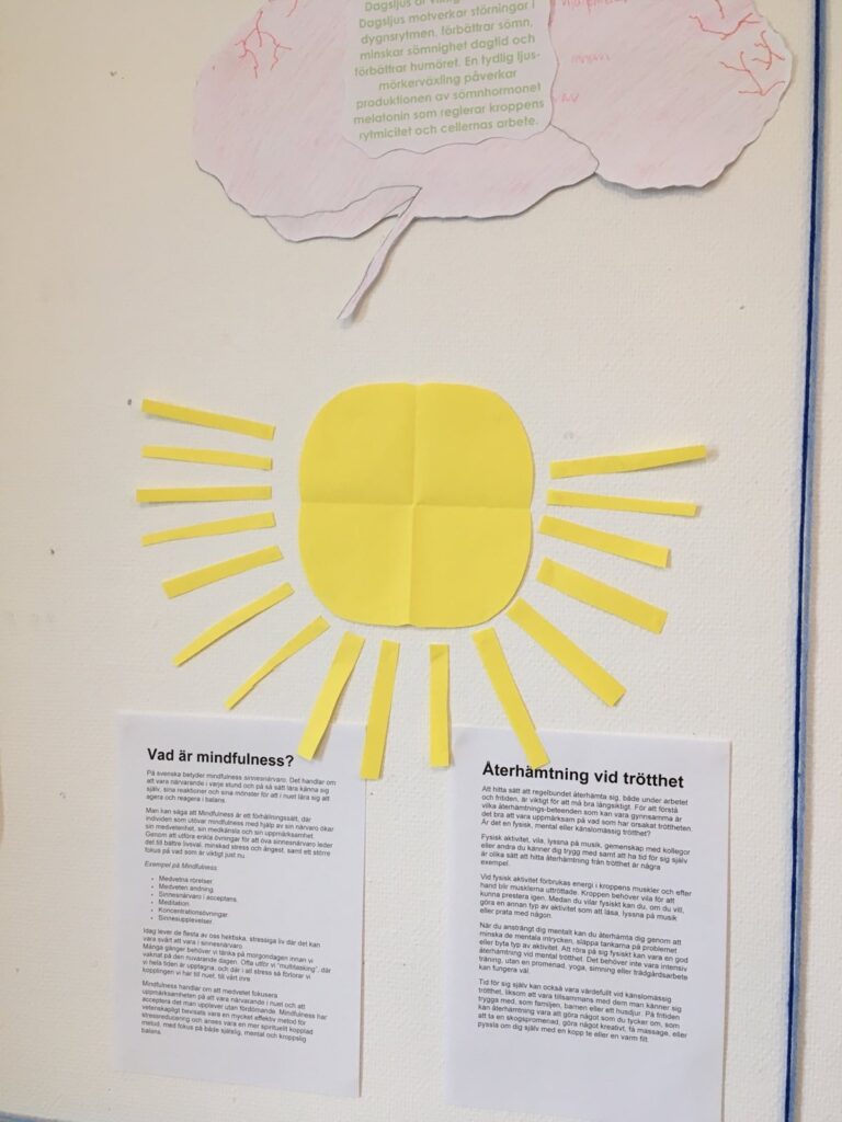 En sol med solstrålar i gult papper, uppklistrat på väggen. Skapat av deltagarna på Nytidas dagliga verksamhet.