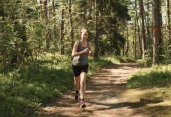 Elisabeth som står i motionsspåret i skogen