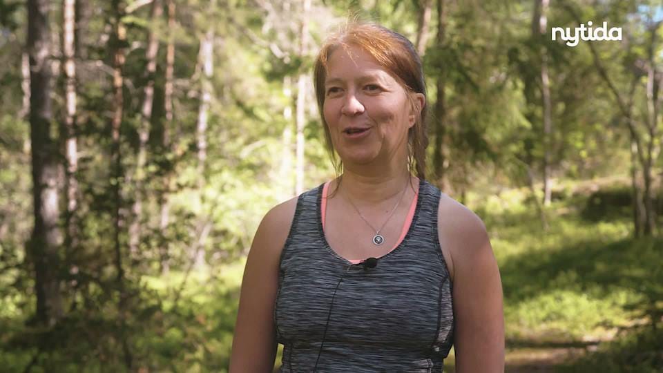 Elisabeth som står i motionsspåret i skogen